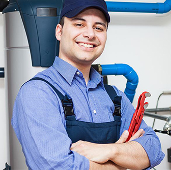 Smiling gas line technician holding a red wrench.