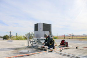 HVAC tech making commercial hvac repairs on rooftop
